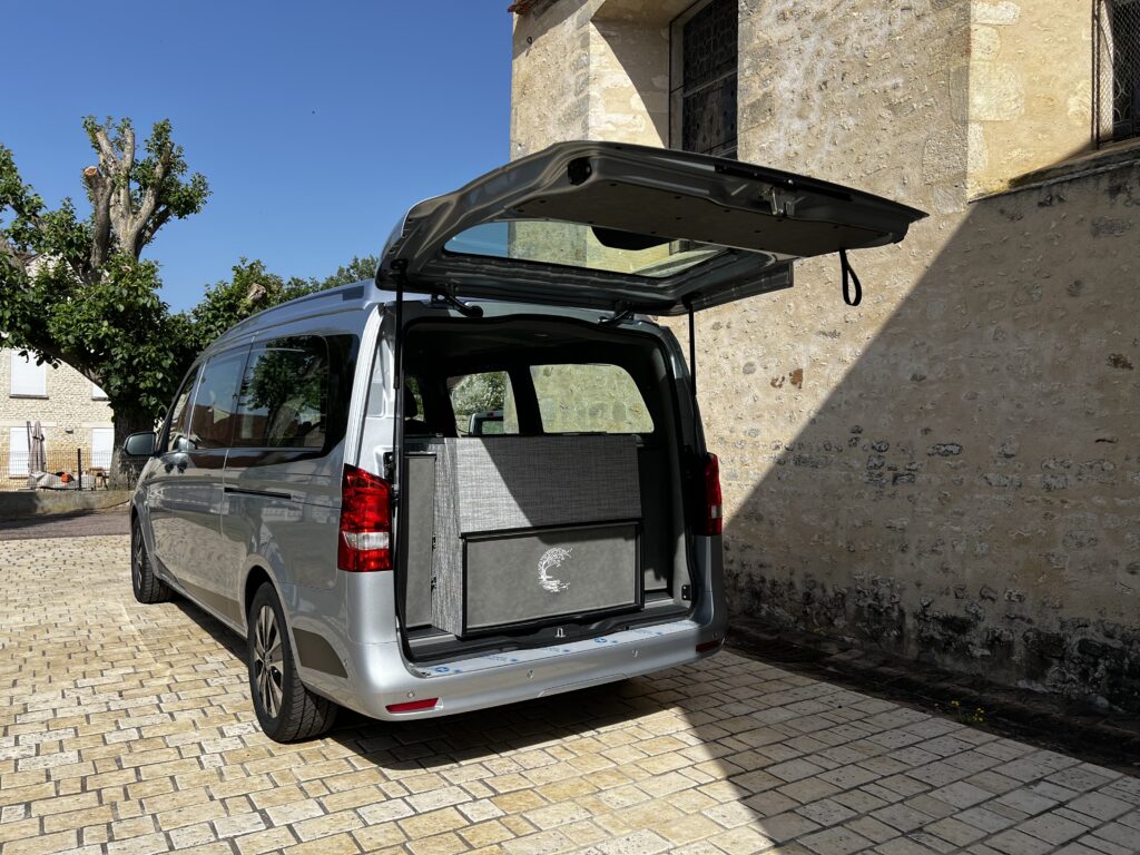 Vue arrière d’un corbillard de cérémonie Iris Luxe sur Mercedes Vito avec hayon arrière vitré et aménagement funéraire COLLET.